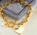 Detail of gold heart pendant bracelet with T-bar toggle clasp on gray velvet display - Gold OT Buckle Rhinestone Heart