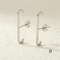 Dettaglio di orecchini a perno argentati a forma di J con strass su sfondo bianco - Stile Lucido Liscio / Stile Lucido Argento (ER0380-D)