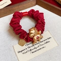 Détail d'un chouchou rouge plissé avec un pendentif cheval doré et une pièce de monnaie - 30# Elastique-Rouge-Cheval-Richesse