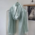 Detail of light green linen scarf featuring delicate white lace trim on soft fabric - Bean Green