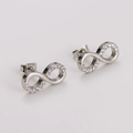 Détail de boucles d'oreilles signe infini avec zircons cubiques sertis sur métal argenté - Boucles d'oreilles couleur acier