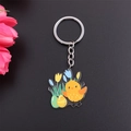 Cartoon Easter keychain featuring a yellow chick, colorful egg, and flower charms - Flower Bush Chick