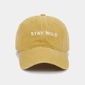 Close-up of white STAY WILD embroidery on washed cotton yellow baseball cap fabric - Adjustable / Yellow