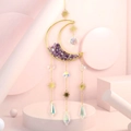 Detail of amethyst moon suncatcher with golden frame and prisms on pink background - Amethyst