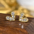 Orecchini a lobo a cuore dorati con zirconi brillanti su uno sfondo di legno - Oro