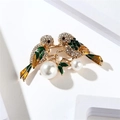 Close-up of enamel magpie bird brooch with green feathers and white pearls on gold branch - Two Birds on a Branch (BC23Y0103)