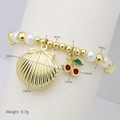 Close-up of pearl bead bracelet with golden shell and red cherry charms and size info - Shell & Cherry Style