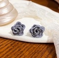 Elegant Morandi gray rose stud earrings with matte texture shown in a pair on ceramic - Gray Matte Rose Flower Studs