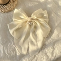 Elegant cream silk butterfly hair claw clip with pearl pendant detail on paper backdrop - White