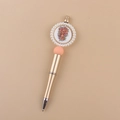 Detail of champagne gold beaded pen with pink sphere and floral pearl-bordered top - Floral Cross/Gold Barrel