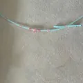 Close-up of sky blue bead necklace with pink crystal stones and handcrafted bow detail - Blue And Pink Beaded Style