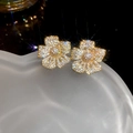 Detailaufnahme goldener Blumenohrstecker mit glänzenden weißen Zirkonia-Steinen - Blumenstil / Gold (925 Sterling Silber Ohrringstift)