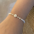 Wrist shot of beaded shell bracelet with golden letter W charm on white beads - Letter W Style (W)