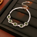 Detalle de pulsera plateada con piedras cuadradas verdes y cristales pavé brillantes - Verde