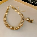 Luxury gold necklace and earrings set with champagne zircon stones on a beige tray - Champagne