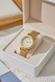 Detailed shot of a gold quartz watch with rhinestones and Roman numerals in a gift box - Gold