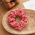 Close-up of red and white snowflake pattern bow scrunchie on a woven tray - Basic Style / Christmas Red White