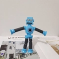 Robot giocattolo blu con ventose e arti telescopici sopra una rivista - Senza Luce / Blu