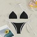 Flat lay of black and white color block bikini set on a textured beige woven mat - Black