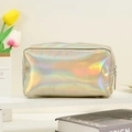 Detailed view of iridescent holographic cosmetic bag on a white shelf with flowers - Light gold