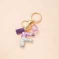 Letter F keychain with purple resin glitter, tassel and golden hardware accessory - Letter F