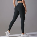 Close-up of black high-waisted yoga pants with lift-up seams and matte fabric texture - S / Bottoms / Black