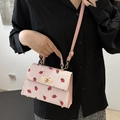 Pink corduroy crossbody bag with embroidered strawberries and a golden metal lock - Pink