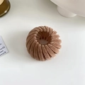 Close-up of brown velvet bird nest hair clip with retractable teeth for bun styling - Velvet Khaki
