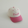 Detalle de gorra infantil bicolor con visera rosa, cuerpo crema y bordado Burnette - Rosa