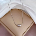 Vista macro di un ciondolo rettangolare in argento lucido su una catena sottile e seta bianca - Pendaglio a Chicco d'Amore (K104 Argento) / Argento