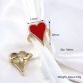 Golden open heart ring with red enamel inlay and white zircon accents on white silk - Red