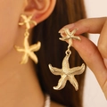 Golden starfish drop earrings with fine stippled texture in a beach vacation style - Gold Layered Starfish Earrings