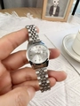 Detailed close-up of a silver stainless steel watch with a round dial and date calendar - White
