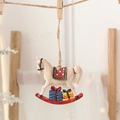 Resin rocking horse Christmas ornament with red base and festive saddle hanging on rope - Rocking Horse