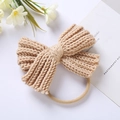 Detailed view of handmade beige knitted bow headband with soft woolen texture for babies - Khaki