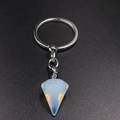 Macro detail of hexagonal opal pendant with blue fire on silver keychain ring - Opalite