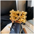 Detail view of a gold hardshell clutch bag with decorative beads and chain strap - Gold