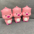 Detailed view of three pink Loopy slow rebound stress relief toys on a soft gray sofa - Pink Small Beaver 10.5cm