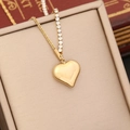 Gros plan du collier avec pendentif cœur doré et strass présenté dans un écrin - Style Strass Love (7#)