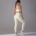 Detail van de sportbeha met kruisbandjes en beige yoga-leggingset met hoge taille - S / Licht Ivoor
