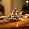 Dettaglio del villaggio di Natale luminoso con treno rotante e calde luci a LED - Babbo Natale