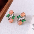 Dettaglio di orecchini vintage in bronzo con pietre ovali rosa e cristalli verdi - Orecchini a fiore con gemme ovali rosa (ago d'argento)