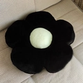 Plush flower-shaped seat cushion in black and white faux fur on a fabric sofa - Black