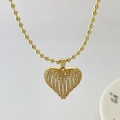 Detail eines goldenen Herzanhängers mit hohler Streifenstruktur und Zirkonia-Besatz - Klein (nur Anhänger) / Gold