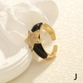 Detaillierte Nahaufnahme eines goldener Sternrings mit schwarzer Emaille und Kristallen - Einstellbar Offen / Stern / Schwarz