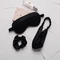 Black silk sleep set featuring padded eye mask, large scrunchie, and elastic headband - Black