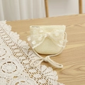 Close-up of beige woven mini crossbody bag with a large polka dot lace bow decoration - Bag-Creamy White