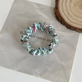 Detailed close-up of light blue floral satin scrunchie on a decorative wood slice - Flower Blue