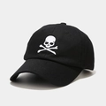 Dettaglio del ricamo teschio bianco su un cappellino da baseball nero in cotone - Regolabile / Nero