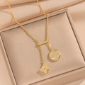 Collier double trèfle plaqué or avec pendentifs sertis de diamants sur écrin beige - 509 Collier Trèfle à Gland Doré